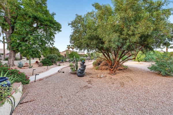 Combining covered seating, grilling space, and scenic backyard views, this outdoor living area is ideal for entertaining and relaxation. The thoughtfully landscaped setting enhances the property's appeal.