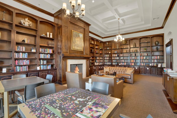 Extensive shelving, gathering tables, and comfortable seating create a versatile community space ideal for reading, games, educational activities, and social events.