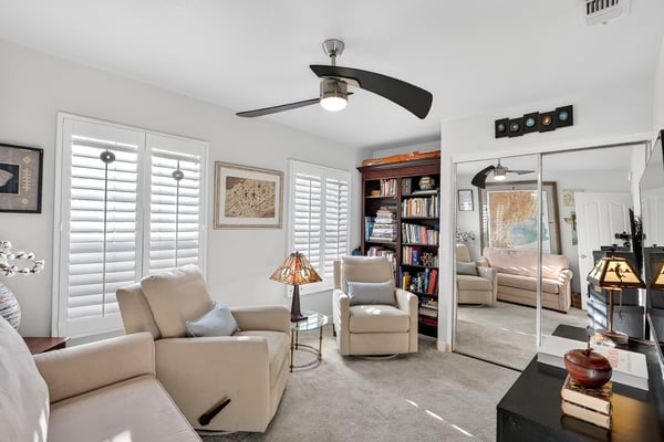 This bright secondary bedroom offers plantation shutters, mirrored closet doors, and flexible living space. Ideal for overnight guests or a private retreat, it complements the home's functional floor plan.
