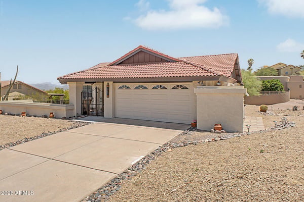 This charming home features a covered entry, spacious driveway, and thoughtfully designed exterior. The elevated setting enhances privacy while embracing the natural beauty of the surrounding desert landscape.