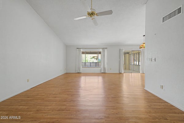 Designed for comfort and flexibility, this open living area features large windows, soaring ceilings, and abundant natural light. The layout seamlessly supports both everyday living and entertaining.
