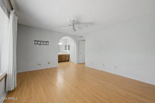 This large primary suite offers a comfortable setting with natural light, a ceiling fan, and direct access to the ensuite bath. The open layout creates a relaxing environment perfect for everyday living.