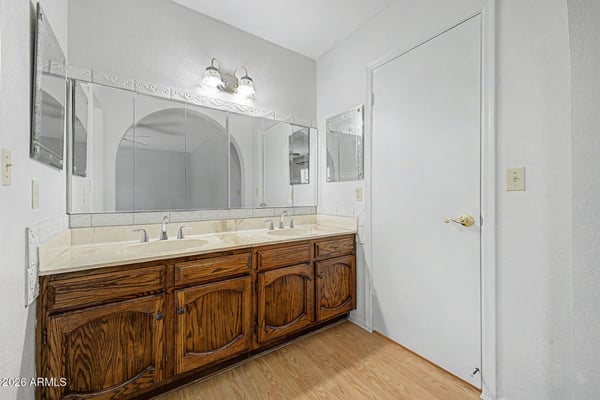 The bathroom's dual-sink vanity provides extensive storage, generous countertop space, and large mirrors for added convenience. Thoughtful design elements support both functionality and everyday comfort.