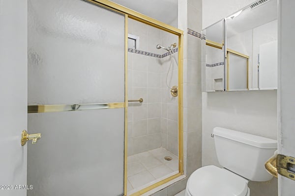 This bathroom features a spacious walk-in shower with glass enclosure, tile finishes, and convenient accessibility enhancements. The clean design offers both practicality and long-term usability.