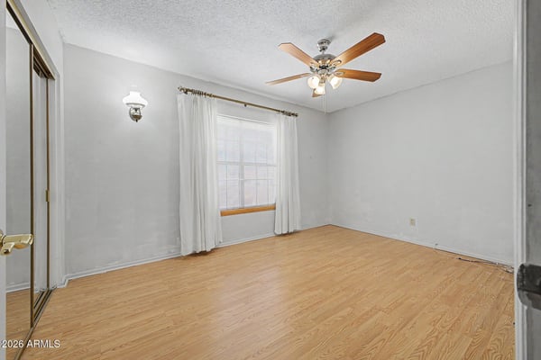 This bright secondary bedroom offers natural light, a ceiling fan, and attractive flooring. Its versatile layout makes it ideal for guests, family, remote work, or creative hobbies.