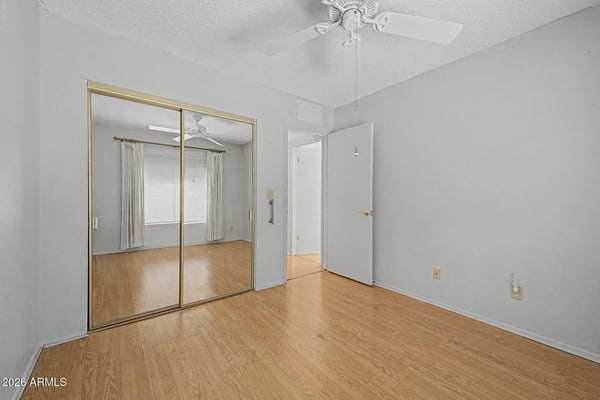 Mirrored closet doors and a generous floorplan make this secondary bedroom feel open and inviting. The adaptable space is well-suited for guests, family members, or a dedicated home office.