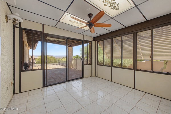 Large windows and tile flooring define this bright Arizona room, creating a comfortable extension of the home's living space. Perfect for entertaining, reading, or enjoying views of the surrounding landscape.