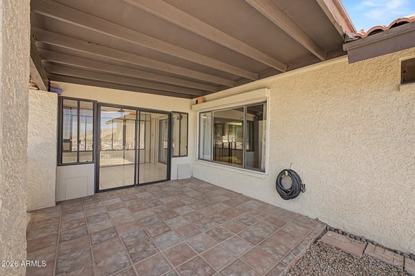 This covered patio provides a comfortable outdoor gathering space with direct access to the enclosed Arizona room. The low-maintenance design enhances everyday enjoyment and outdoor entertaining possibilities.
