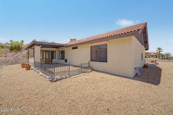 The expansive backyard showcases easy-care desert landscaping and open outdoor space. Thoughtfully designed for minimal maintenance, it offers privacy and room to enjoy Arizona's outdoor lifestyle.