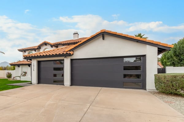 Expansive three-car garage with sleek contemporary doors and ample driveway space. Ideal for vehicles, storage, and everyday convenience in this beautifully renovated Scottsdale home.