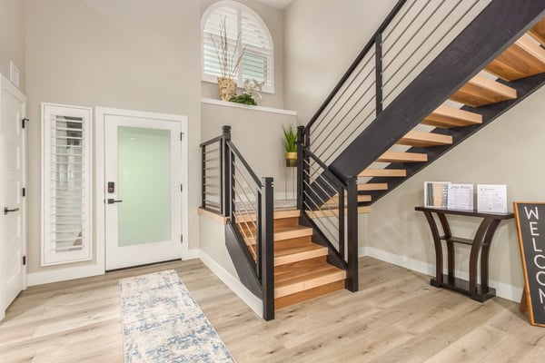 Impressive entryway featuring soaring ceilings, contemporary flooring, plantation shutters, and a custom staircase. A bright and sophisticated introduction to this updated Scottsdale property.