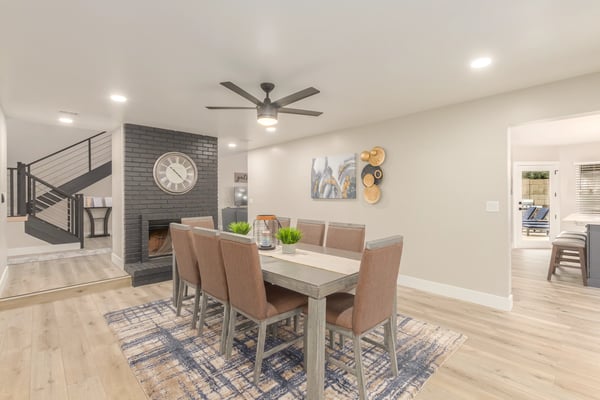 Elegant dining area highlighted by a painted brick fireplace, updated finishes, and open-concept flow. Perfect for entertaining guests in this stylish Scottsdale home.