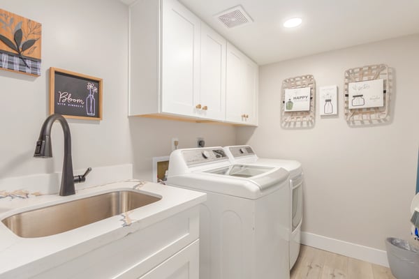 Well-designed laundry space featuring extensive cabinetry, utility sink, modern finishes, and efficient workflow. An upgraded Scottsdale home amenity that adds convenience.
