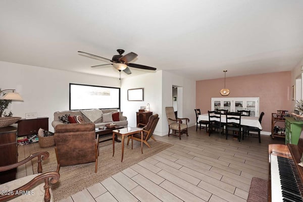 Bright and open, this combined living and dining room features expansive windows, durable tile flooring, and a layout designed for comfortable living. The spacious design accommodates both entertaining and everyday activities.