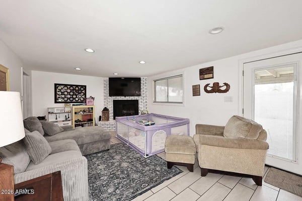 A spacious secondary living room provides flexibility for a media room, playroom, or casual gathering space. The fireplace, bright finishes, and open layout make this a standout feature of the home.
