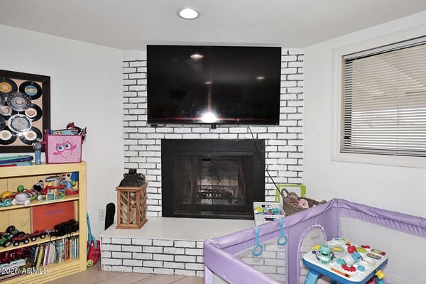 A stylish brick fireplace serves as the focal point of this comfortable family room, offering warmth, character, and entertainment potential. Recessed lighting and easy-care tile flooring complete this versatile living space.