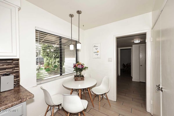 Large windows fill this breakfast nook with natural light, creating a welcoming space for dining and conversation. Positioned beside the kitchen, it provides convenience and a bright everyday gathering spot.