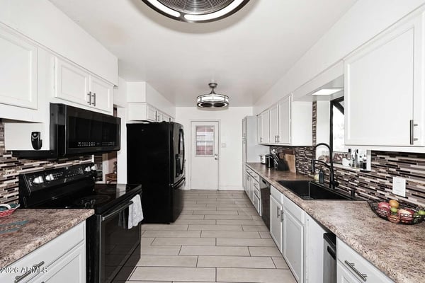 This expansive kitchen offers extensive cabinet storage, abundant prep space, and modern finishes throughout. The efficient layout supports everyday cooking while maintaining excellent flow within the home.