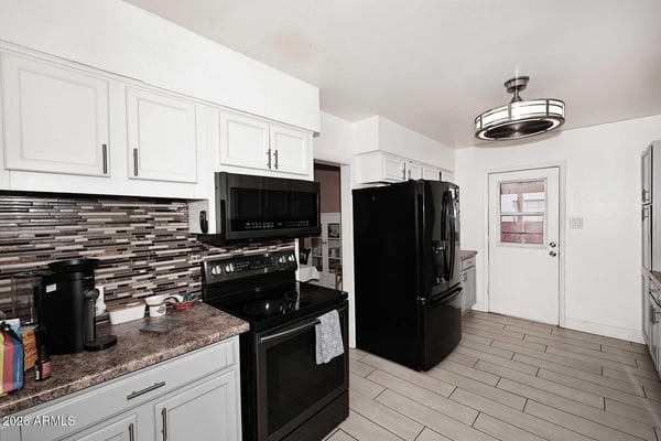 Abundant cabinetry, quality appliances, and attractive backsplash details highlight this inviting kitchen. The spacious design offers exceptional storage and workflow for daily living.