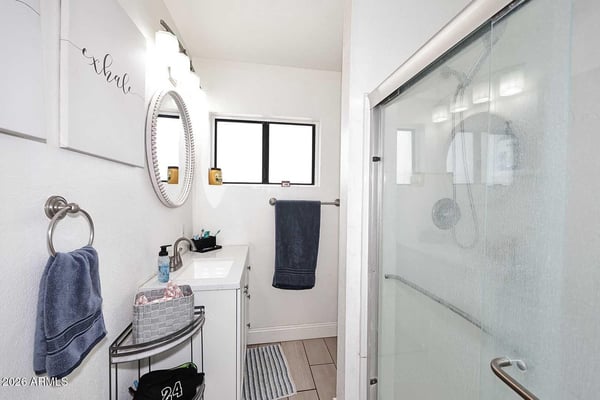 This updated bathroom features a sleek vanity, glass shower enclosure, and bright finishes that create a fresh, contemporary feel. The functional layout offers comfort and convenience for family and guests.