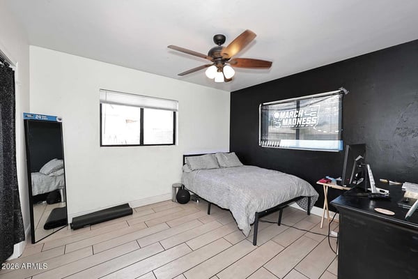 A spacious secondary bedroom with tile flooring, ceiling fan, and abundant natural light. The versatile floor plan easily accommodates guests, family members, or a home office setup.