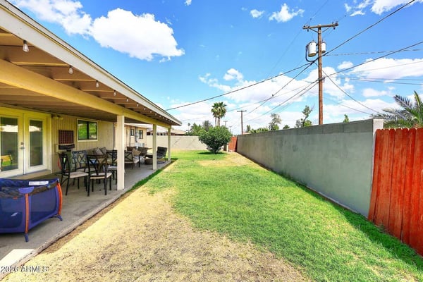 The expansive backyard showcases a large covered patio, grassy lawn, and multiple seating areas ideal for outdoor dining and gatherings. This versatile outdoor space enhances everyday living and entertaining opportunities.