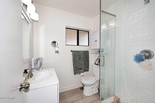 This private bathroom features a glass-enclosed shower, updated fixtures, and a clean, bright design. The functional layout provides convenience while complementing the primary suite.