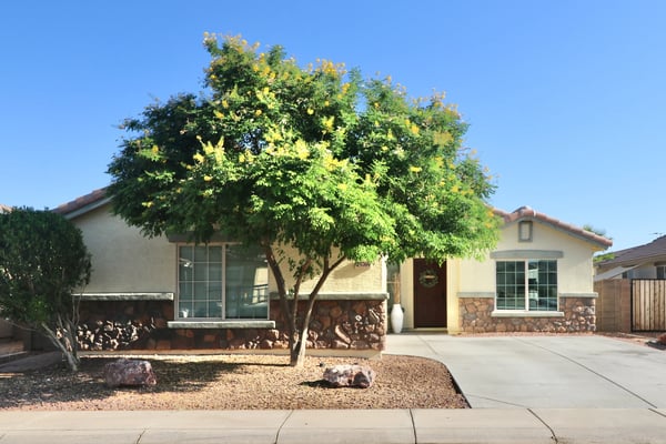 This attractive Buckeye home welcomes you with mature shade trees, stone-accented architecture, desert landscaping, and a spacious driveway leading to the attached two-car garage. Exceptional curb appeal makes a lasting first impression.