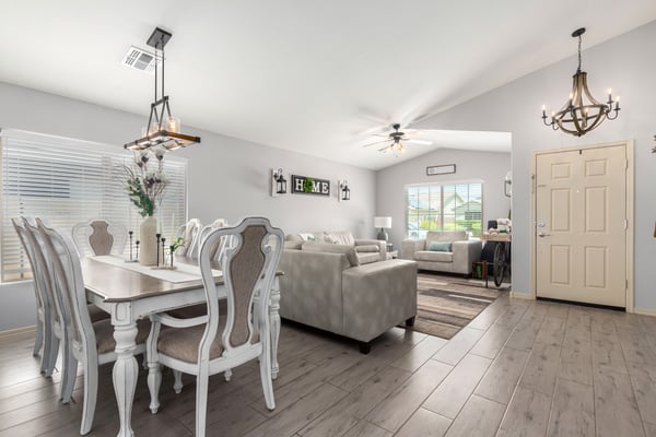 The open floor plan effortlessly connects the dining and living areas, creating an inviting atmosphere enhanced by modern flooring, designer lighting, and abundant natural light throughout.