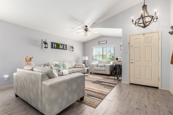 Bright windows, vaulted ceilings, updated flooring, and tasteful finishes make this inviting living room an ideal space for relaxing while enjoying the home's open-concept design.