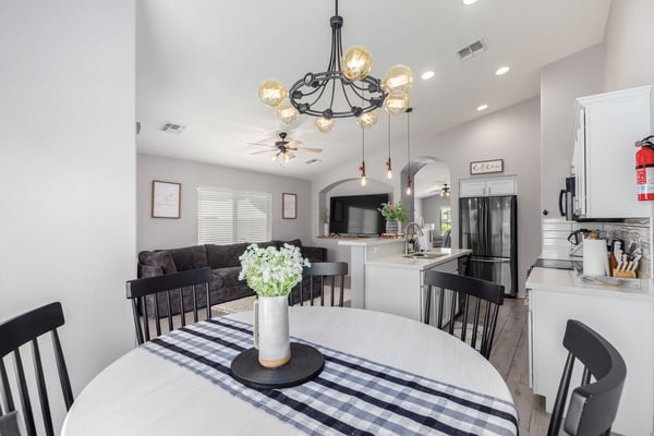 The open dining area overlooks the modern kitchen and spacious family room, creating an ideal layout for entertaining. Updated lighting, soaring ceilings, and contemporary finishes enhance the home's appeal.