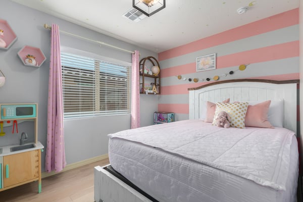 This charming secondary bedroom features updated flooring, large windows, and flexible space perfect for children, guests, or a home office, adding versatility to this beautiful Buckeye home.