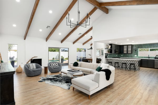 A spectacular open-concept living area combines vaulted ceilings, exposed beams, wide-plank flooring, and a gourmet kitchen to create the perfect space for entertaining and everyday living in this beautifully renovated Scottsdale home.