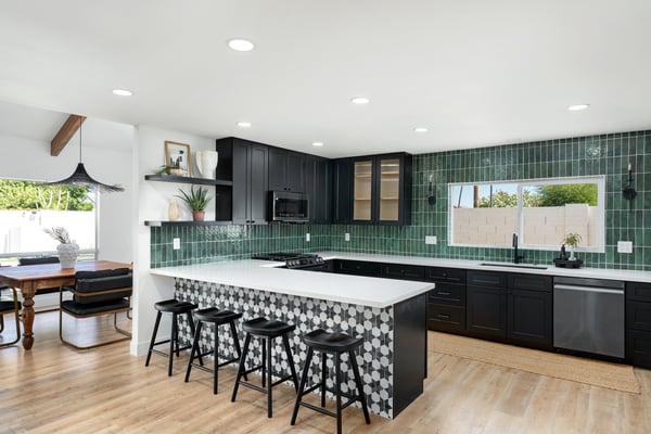 Gather around the oversized quartz island in this stunning chef's kitchen featuring custom cabinetry, designer finishes, stainless steel appliances, and an open layout perfect for entertaining family and guests.