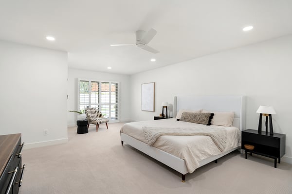 Unwind in this spacious primary suite featuring plantation shutters, soft natural light, generous proportions, and a peaceful atmosphere designed for comfort after a busy day.