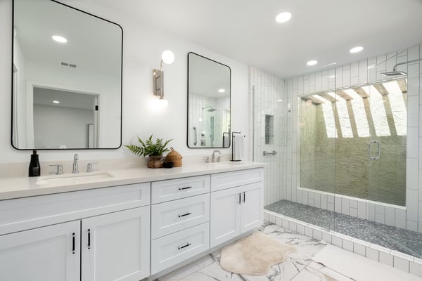 Thoughtfully updated with dual sinks, quartz counters, oversized framed mirrors, and a spacious walk-in shower, this elegant primary bath offers a spa-inspired experience designed for everyday comfort.