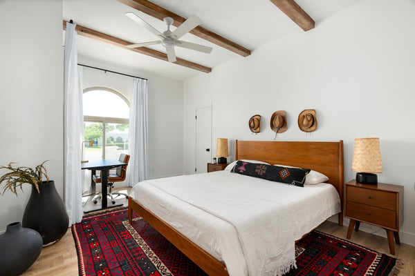 Exposed ceiling beams, rich wood flooring, and generous natural light define this versatile bedroom, offering flexible use as a guest room, office, or private retreat within this beautifully updated Scottsdale home.