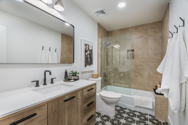 Modern finishes, elegant tile work, a sleek vanity, and updated fixtures make this beautifully renovated bathroom both functional and stylish, complementing the home's extensive renovations.