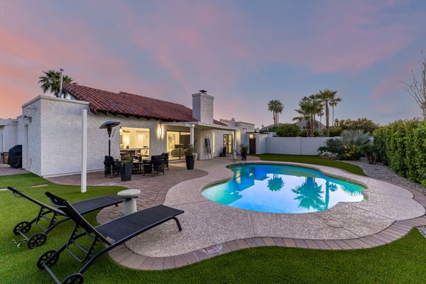 Enjoy the beauty of Scottsdale evenings from this stunning backyard featuring a sparkling pool, spacious patio, mature landscaping, and inviting outdoor living spaces designed for year-round enjoyment.
