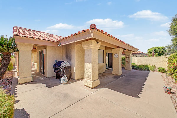 Covered patio provides shaded outdoor living surrounded by attractive desert landscaping, creating an ideal space for relaxing or entertaining year-round in Scottsdale.