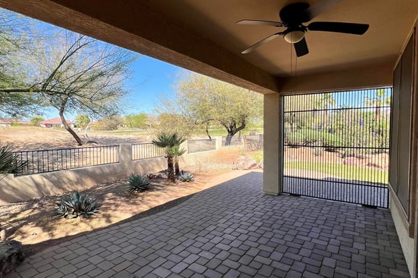 Covered patio featuring paver flooring, ceiling fan, screened enclosure, and peaceful views overlooking the golf course and professionally landscaped backyard. An ideal extension of the home's indoor living space.