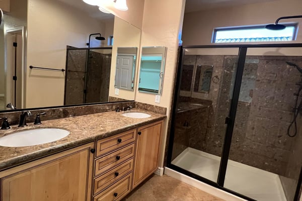 Beautiful primary bath offering dual vanities, abundant cabinetry, upgraded countertops, modern fixtures, and a spacious tiled walk-in shower. A relaxing retreat designed with both comfort and functionality in mind.