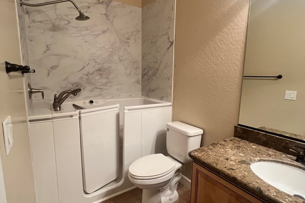 Well-appointed guest bathroom featuring a convenient walk-in tub, updated vanity, durable tile flooring, and attractive finishes that provide comfort, accessibility, and everyday functionality.