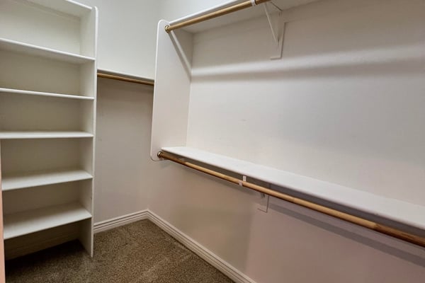 Large walk-in closet complete with built-in shelving, multiple hanging sections, and spacious storage designed to keep clothing and accessories neatly organized.