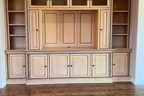 Beautiful custom entertainment wall featuring rich built-in cabinetry, open display shelves, enclosed storage, and premium craftsmanship that adds elegance and functionality to the great room.