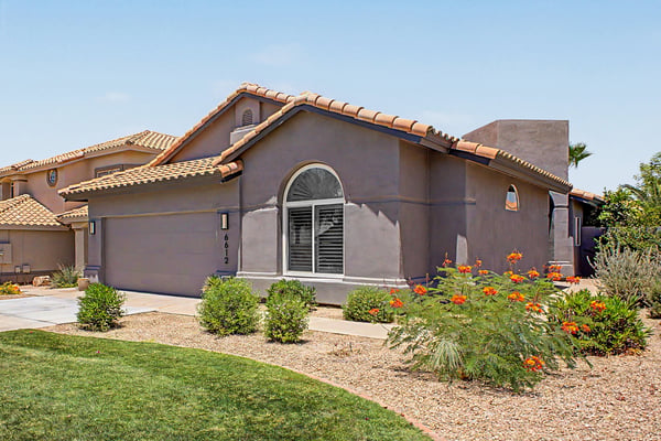 Attractive front exterior featuring mature landscaping, a spacious driveway, and timeless architecture in the desirable Red Mountain Ranch community. This well-maintained home offers exceptional curb appeal from the moment you arrive.