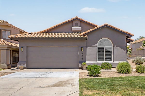 Welcoming front fa ade with a two-car garage, updated exterior finishes, and attractive desert landscaping. A beautifully maintained property offering style, comfort, and low-maintenance living.