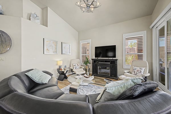 Elegant great room with vaulted ceilings, designer lighting, a beautiful fireplace, and sliding doors leading to the covered patio. This inviting space is ideal for enjoying Arizona's indoor-outdoor lifestyle.