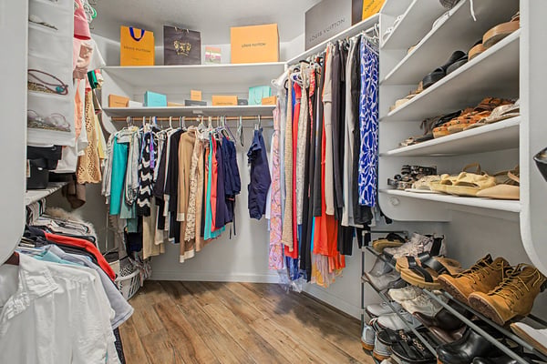 Organized walk-in closet featuring custom shelving, multiple hanging areas, and dedicated shoe storage. An exceptional storage solution that keeps everyday essentials within easy reach.