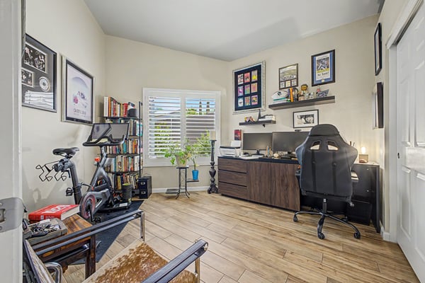 Comfortable office or guest bedroom featuring tile flooring, plantation shutters, spacious layout, and natural light. A versatile room designed to meet a variety of lifestyle needs.